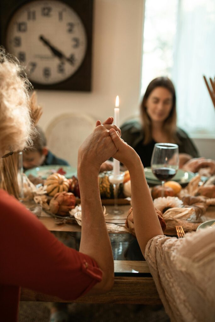 A Family Shows Gratitude around the table by holding hands in a celebratory  dinner.